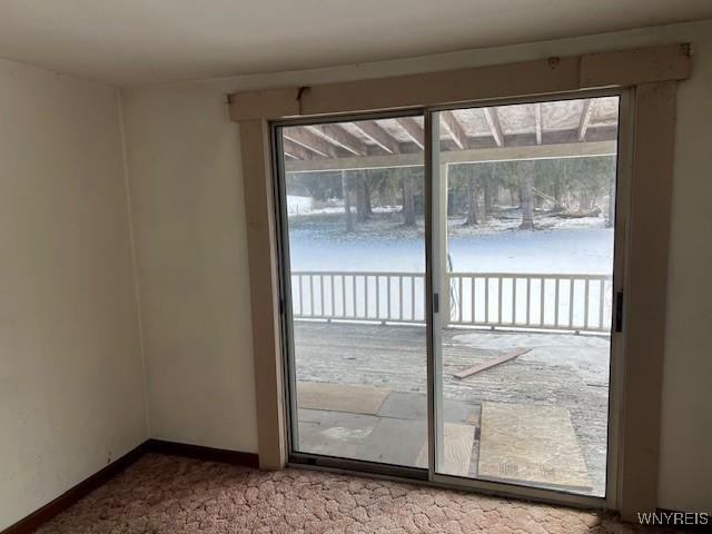 doorway with carpet and baseboards