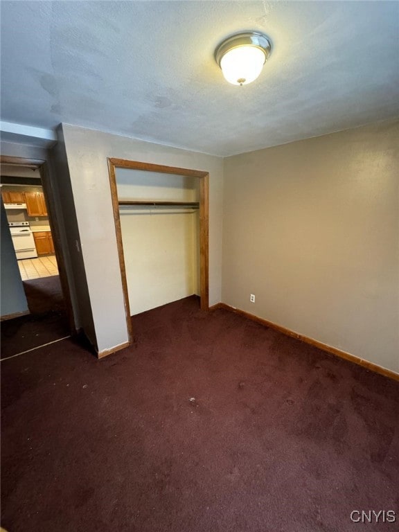 163 E 9th St, Oswego-City, NY 13126 - unfurnished bedroom featuring baseboards, dark carpet, and a closet
