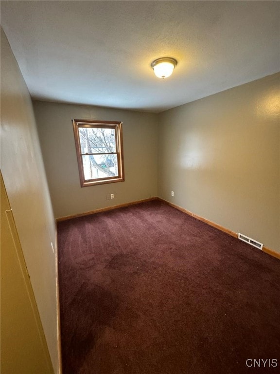 163 E 9th St, Oswego-City, NY 13126 - spare room featuring baseboards, dark colored carpet, and visible vents