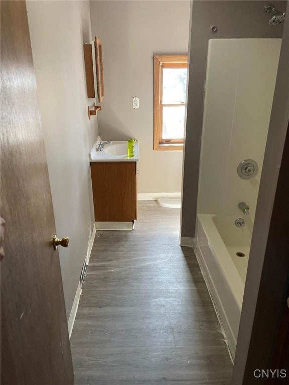 163 E 9th St, Oswego-City, NY 13126 - bathroom with vanity, baseboards, toilet, and wood finished floors