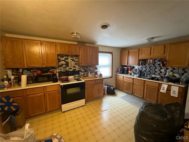 163 E 9th St, Oswego-City, NY 13126 - kitchen with light countertops, backsplash, range with electric cooktop, and brown cabinets