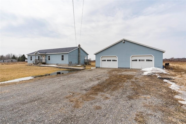 ranch-style home with a garage and an outbuilding