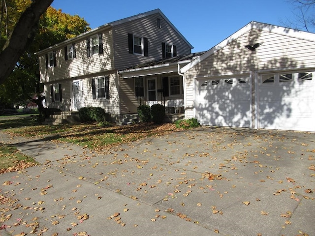 exterior space featuring a garage, covered porch, and concrete driveway