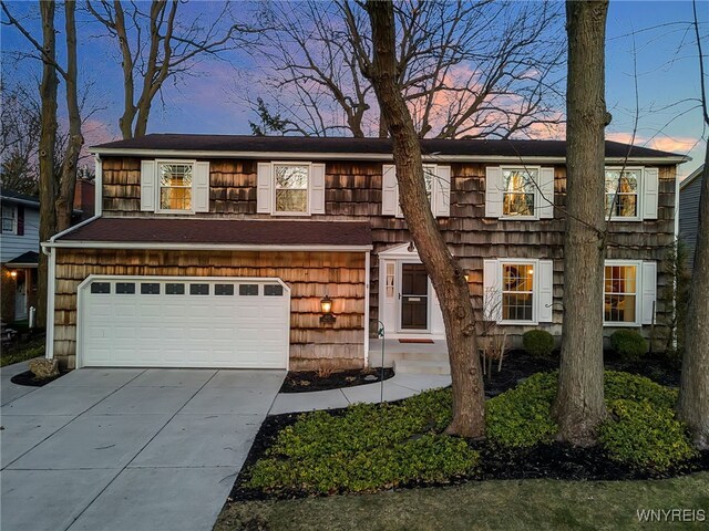 view of property featuring concrete driveway and an attached garage