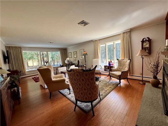 4 Ravine Park N, Oneonta-City, NY 13820 - living area with wood-type flooring, healthy amount of natural light, crown molding, a fireplace with flush hearth, and a baseboard heating unit
