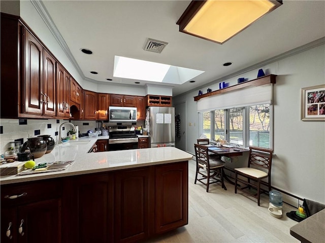 4 Ravine Park N, Oneonta-City, NY 13820 - kitchen featuring appliances with stainless steel finishes, a skylight, ornamental molding, decorative backsplash, and a peninsula