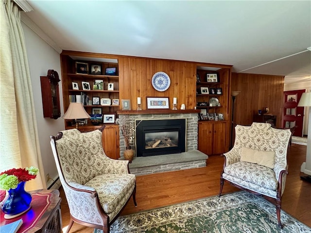 4 Ravine Park N, Oneonta-City, NY 13820 - living area featuring wooden walls, a stone fireplace, wood finished floors, and ornamental molding