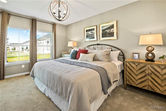 carpeted bedroom with an inviting chandelier and baseboards