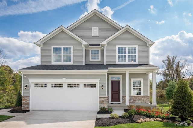 craftsman inspired home with a porch, a garage, stone siding, and driveway