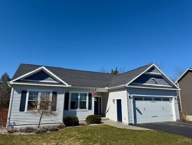 single story home with an attached garage, driveway, and a front yard