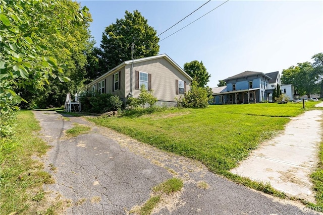 view of home's exterior with aphalt driveway and a lawn