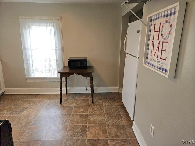 220 Odell Ave, Union, NY 13760 - kitchen featuring baseboards, a healthy amount of sunlight, black microwave, and freestanding refrigerator