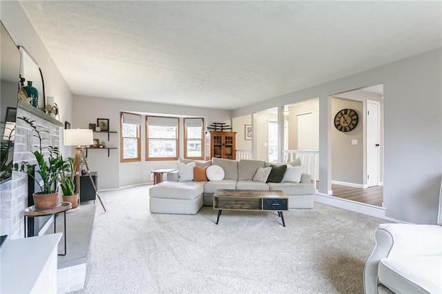 living area featuring baseboards, a textured ceiling, and carpet flooring