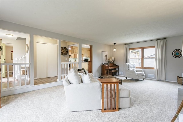 carpeted living room with baseboards and visible vents
