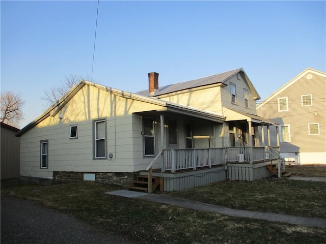 view of property exterior featuring covered porch and a chimney
