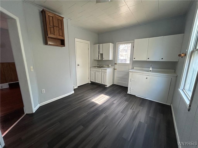 kitchen featuring baseboards, dark wood-type flooring, white cabinets, and light countertops