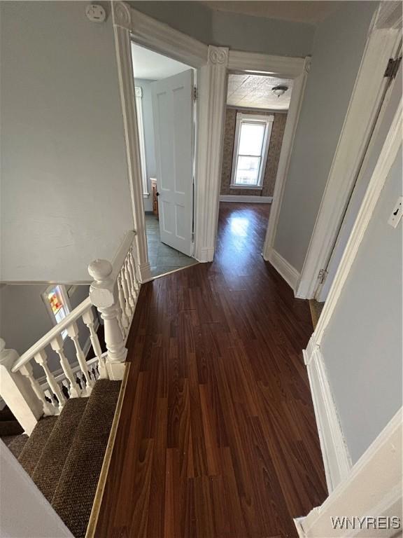 hall featuring stairway, baseboards, and wood finished floors