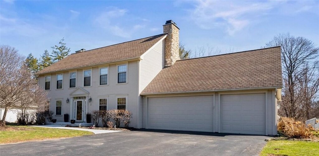 2 Bridgewood Dr, Greece, NY 14612 - colonial inspired home with an attached garage, a chimney, and roof with shingles