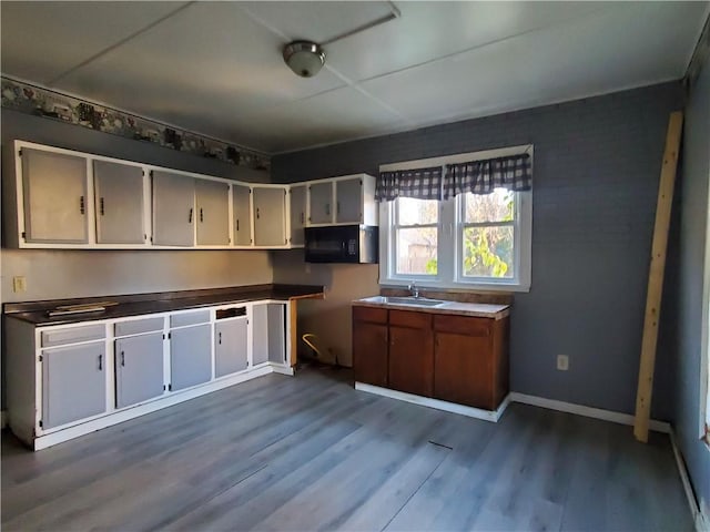 460 S Ave, Elmira-City, NY 14904 - kitchen with dark wood finished floors, black microwave, baseboards, and a sink