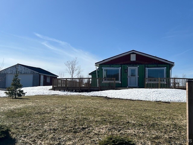 rear view of property with an outbuilding, a yard, and a deck