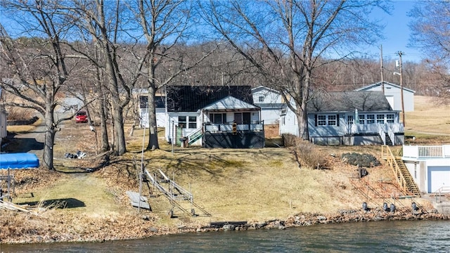 back of house featuring a deck with water view and stairs