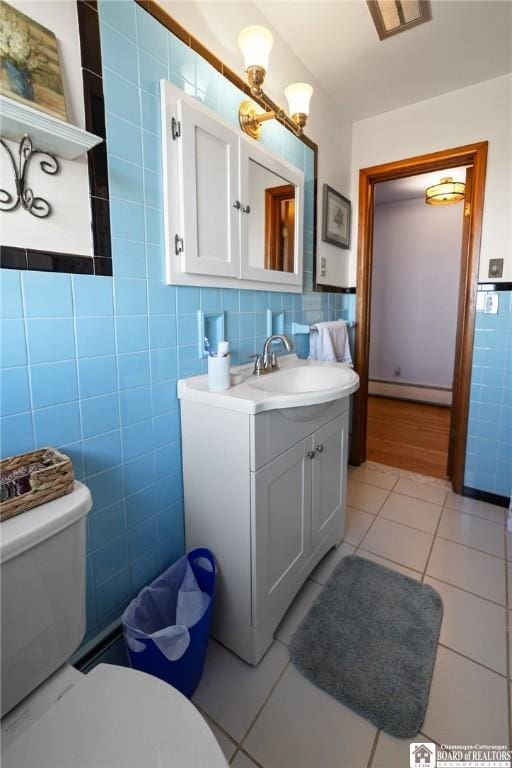 92 E Pine St, Dunkirk-City, NY 14048 - bathroom with toilet, vanity, tile patterned floors, tile walls, and a baseboard radiator