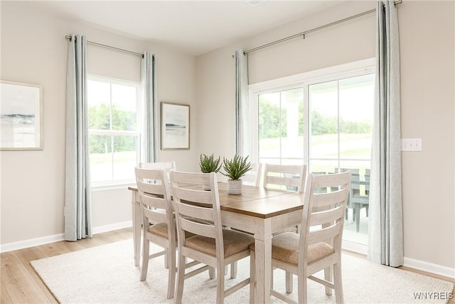 dining room featuring baseboards and light wood-type flooring