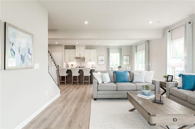 living room featuring stairway, recessed lighting, light wood-style floors, and baseboards