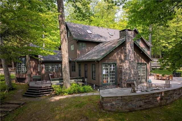 196 Wellington Ln, Springfield, NY 13326 - rear view of house featuring a patio, a chimney, a deck, and a shingled roof