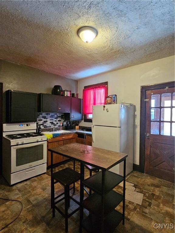 406 S George St, Rome-Inside, NY 13440 - kitchen with white appliances, tasteful backsplash, and a textured ceiling