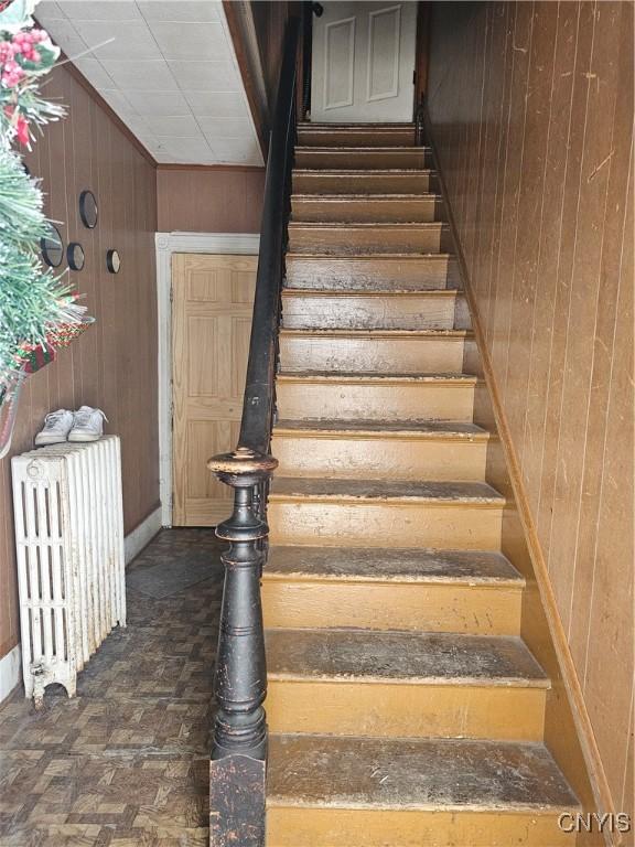 406 S George St, Rome-Inside, NY 13440 - staircase with wooden walls and radiator heating unit