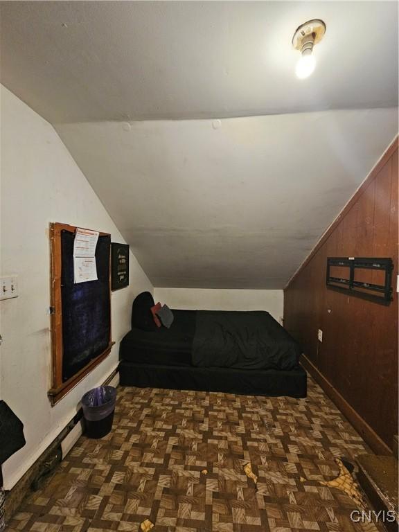 406 S George St, Rome-Inside, NY 13440 - bedroom featuring lofted ceiling, wooden walls, and baseboards