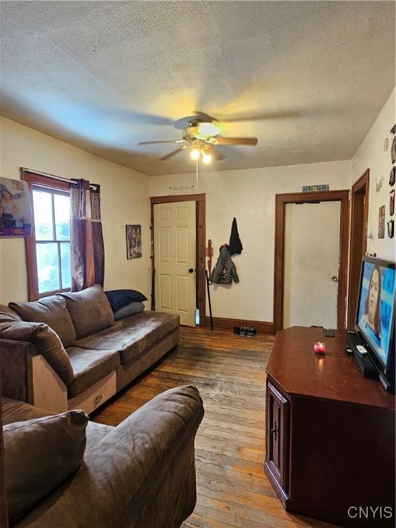 406 S George St, Rome-Inside, NY 13440 - living area with a textured ceiling, baseboards, wood-type flooring, and ceiling fan