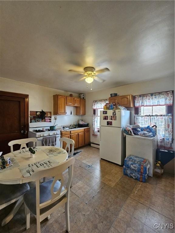 406 S George St, Rome-Inside, NY 13440 - kitchen with brown cabinets, a sink, white appliances, a baseboard radiator, and ceiling fan