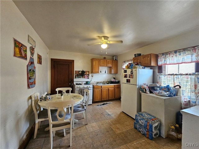 406 S George St, Rome-Inside, NY 13440 - kitchen featuring brown cabinetry, white appliances, light countertops, and a ceiling fan