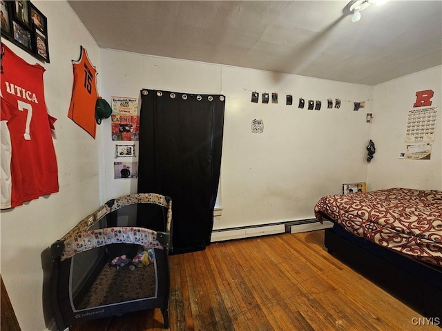 406 S George St, Rome-Inside, NY 13440 - bedroom featuring a baseboard heating unit and wood-type flooring