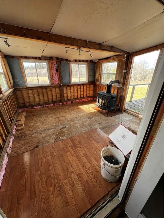 interior space with a wood stove and wood finished floors