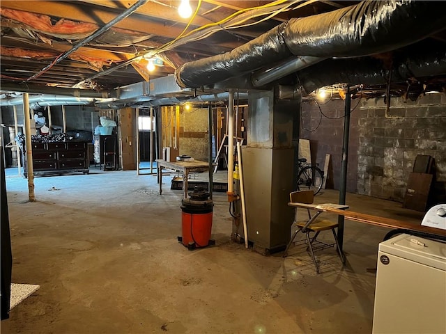 basement featuring heating unit and washer / clothes dryer