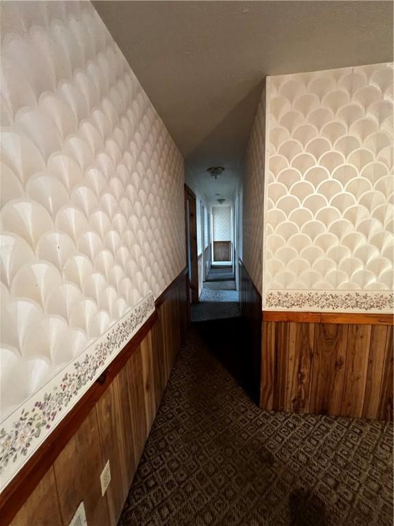 corridor with wallpapered walls and wainscoting