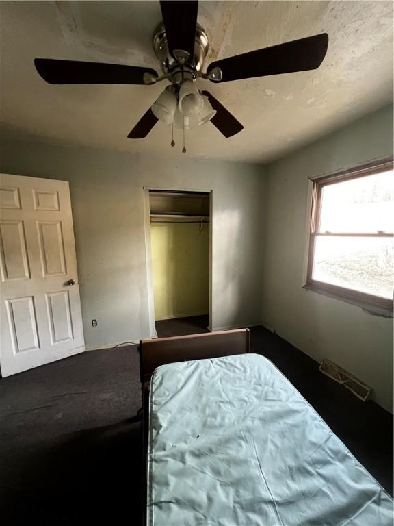 unfurnished bedroom featuring visible vents, a closet, and ceiling fan
