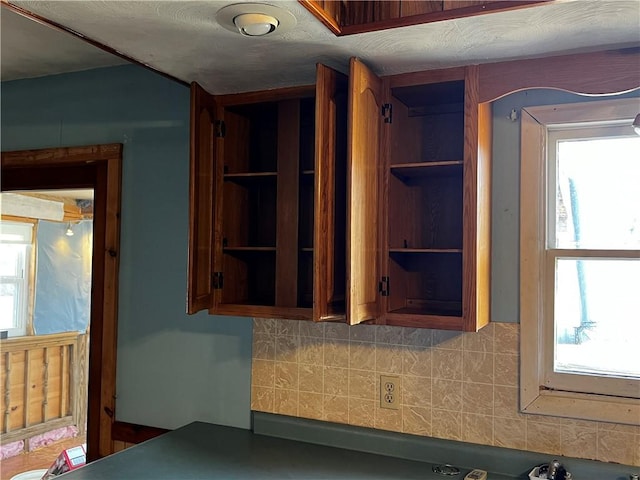 kitchen with dark countertops, open shelves, and a textured ceiling