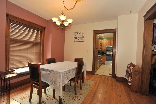 331 W Washington Ave, Elmira-City, NY 14901 - dining room with an inviting chandelier, light wood-style flooring, and baseboards