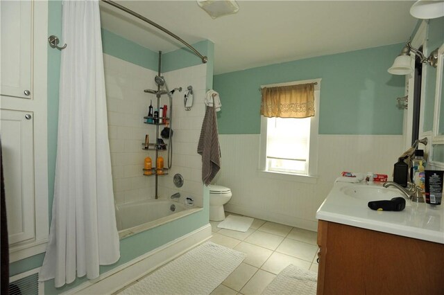 331 W Washington Ave, Elmira-City, NY 14901 - full bath featuring vanity, shower / bathtub combination with curtain, a wainscoted wall, tile patterned floors, and toilet