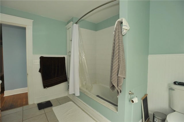 331 W Washington Ave, Elmira-City, NY 14901 - bathroom featuring tile patterned flooring, shower / tub combo, toilet, and a wainscoted wall