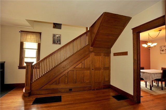 331 W Washington Ave, Elmira-City, NY 14901 - staircase with visible vents, a notable chandelier, wood finished floors, and baseboards