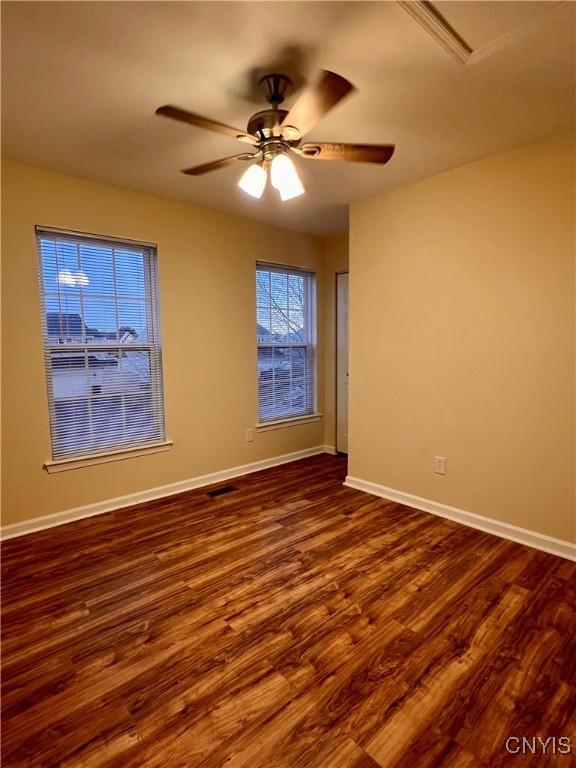 5499 Ravensthorpe, Clay, NY 13041 - spare room with dark wood-style floors, ceiling fan, and baseboards