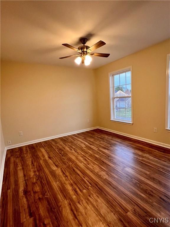 5499 Ravensthorpe, Clay, NY 13041 - spare room featuring dark wood-style floors, ceiling fan, and baseboards