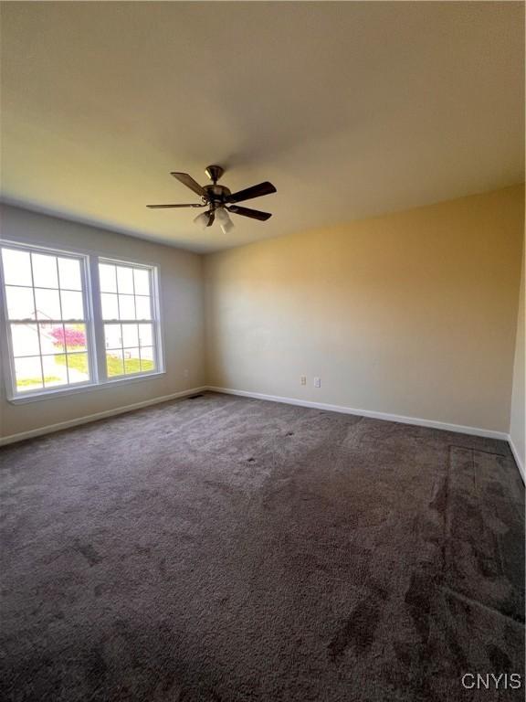 5499 Ravensthorpe, Clay, NY 13041 - unfurnished room with baseboards, dark colored carpet, and a ceiling fan