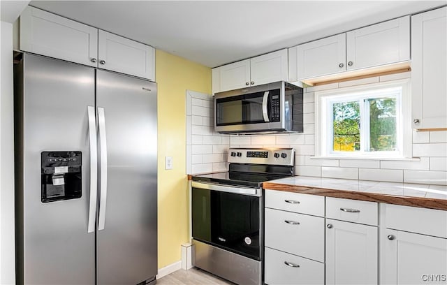 806 Clifford Ave, Vienna, NY 13157 - kitchen featuring decorative backsplash, white cabinetry, stainless steel appliances, and tile counters