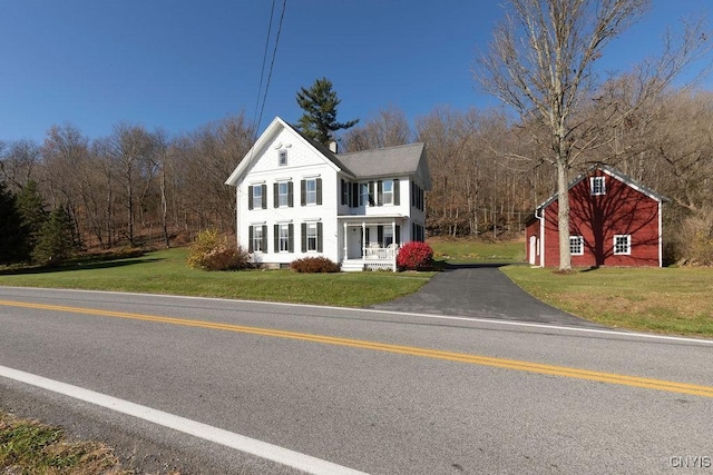 view of front facade with a front yard and aphalt driveway